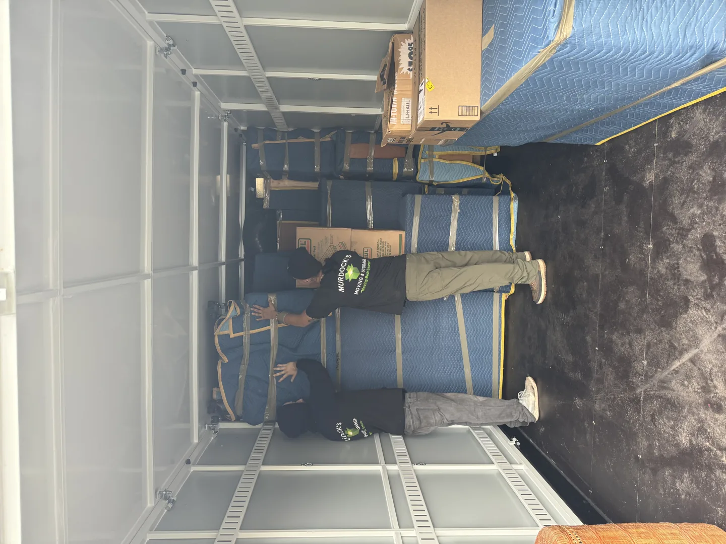 Murdock’s movers organizing boxes inside a moving truck