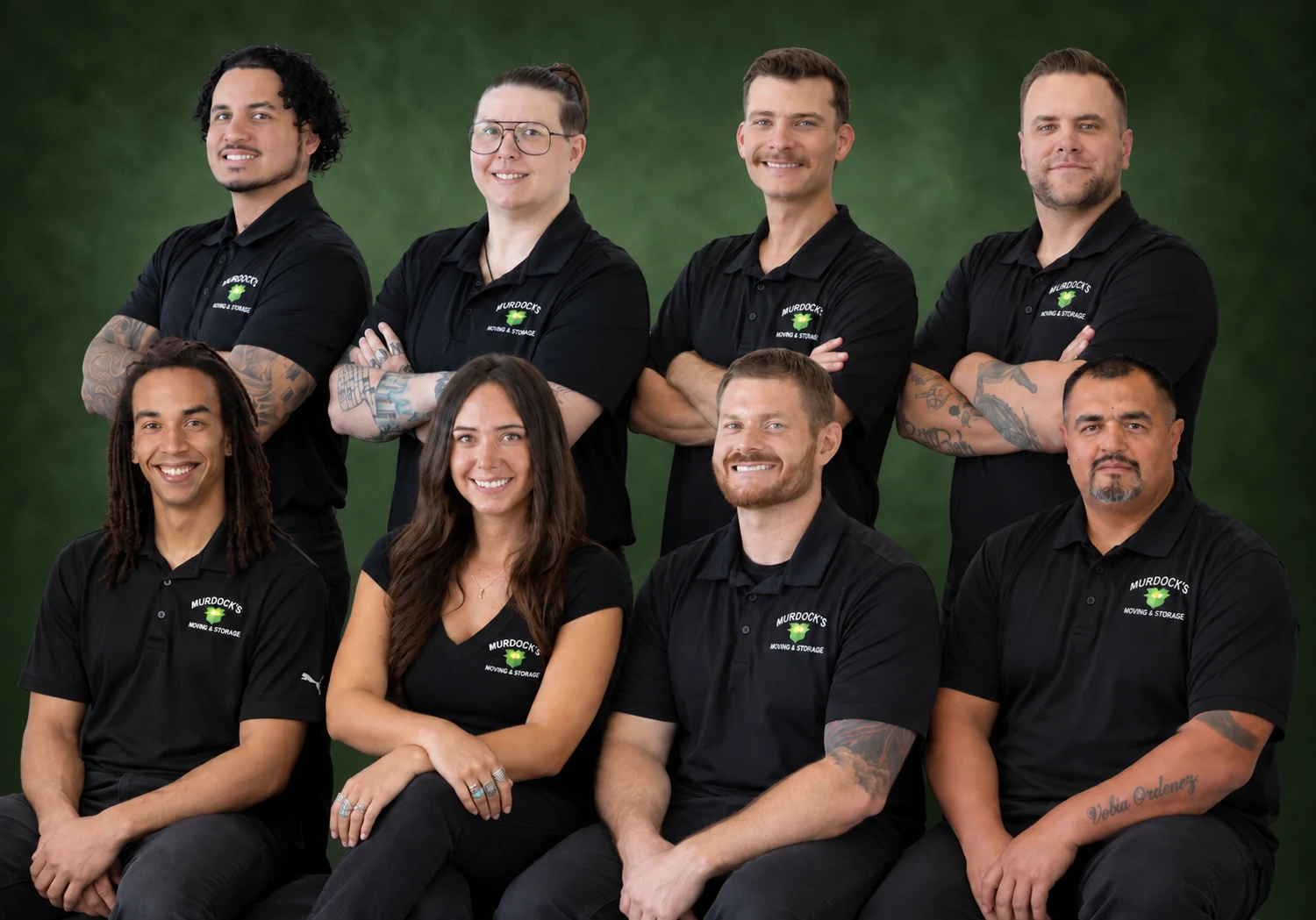 Eight members of the Murdock’s Moving & Storage team together against a green background